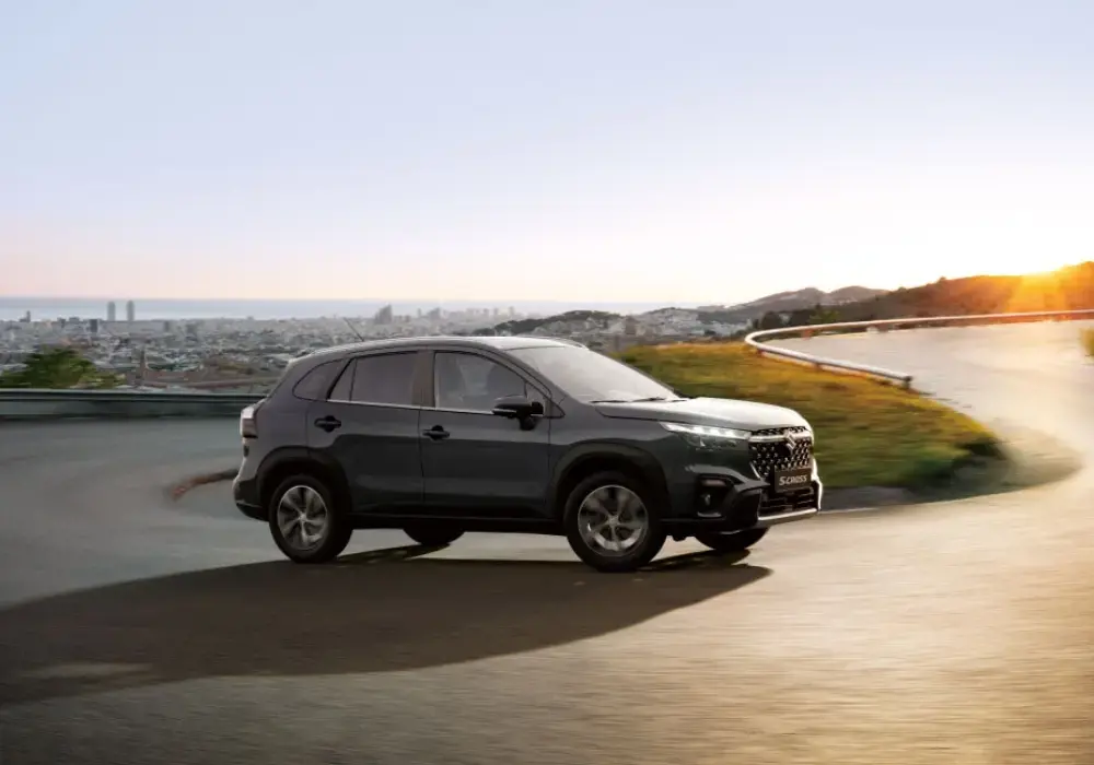 Suzuki S-Cross gris oscuro conduce por una carretera asfaltada curvada